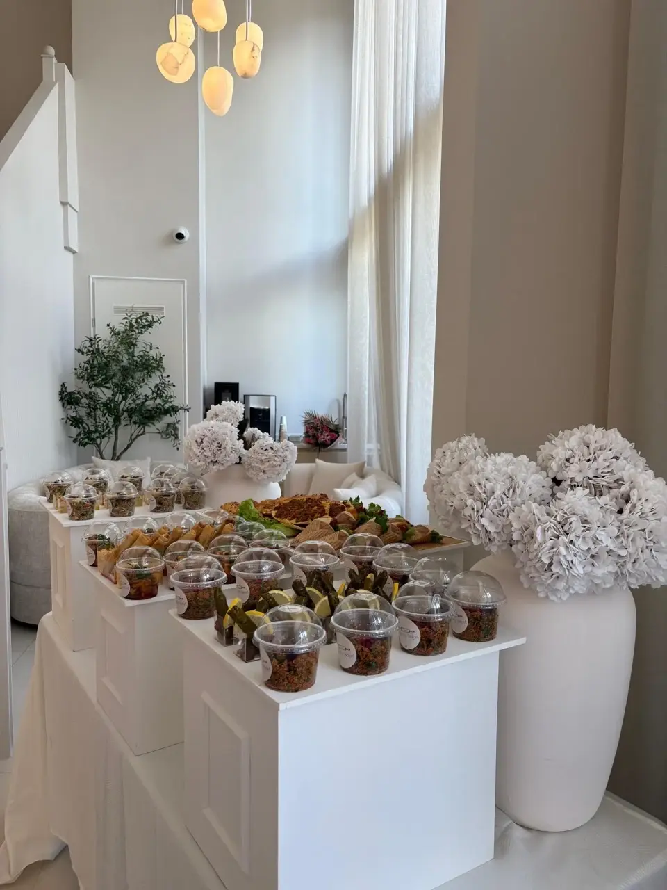 Verzorgde eventtafel met kleine salades en witte bloemen
